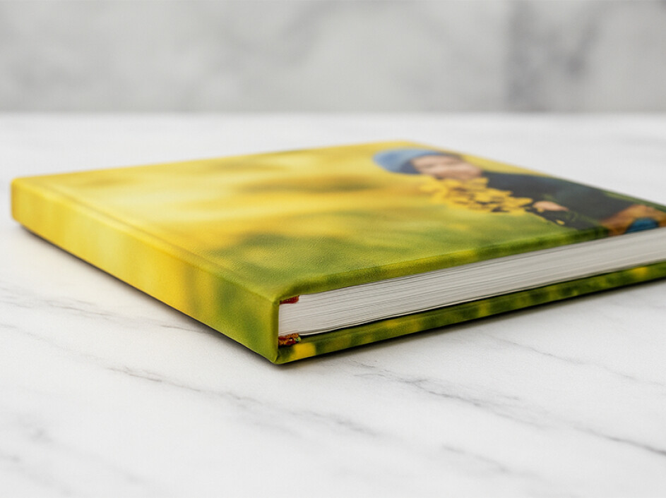 Álbum fotobook premium de lujo Mi Album con empastado fotográfico laminado en frío. Vista cerrada que resalta el grosor de las páginas y la encuadernación de alta calidad, ideal para recuerdos infantiles.