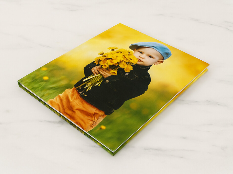 Fotobook Mi Album infantil cerrado en vista superior inclinada, con portada fotográfica laminada en frío.