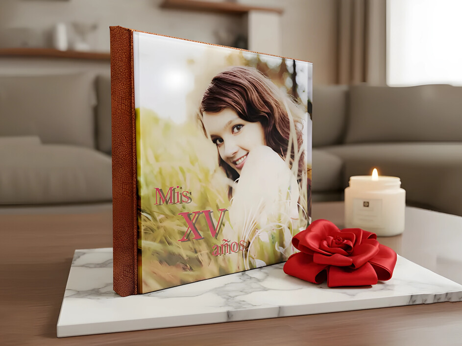 Fotobook de acrílico para XV años con portada personalizada, montado sobre base de mármol y acompañado de una flor roja decorativa, fabricado por Mi Album.