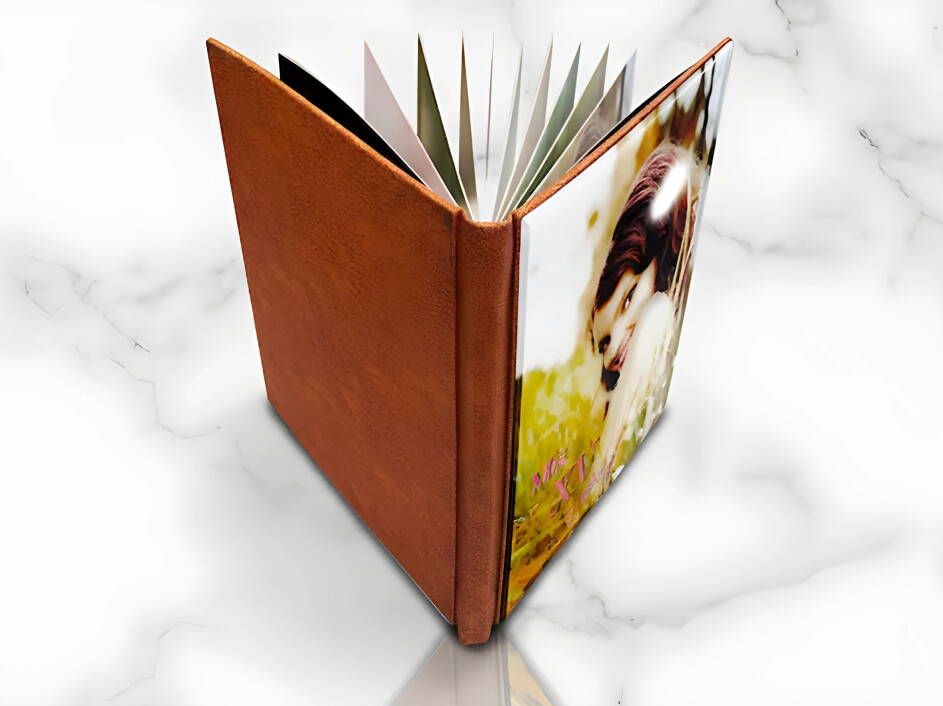 Fotobook de acrílico para XV años abierto en vista superior, con contraportada en pro-piel color miel y páginas layflat, fabricado por Mi Album.