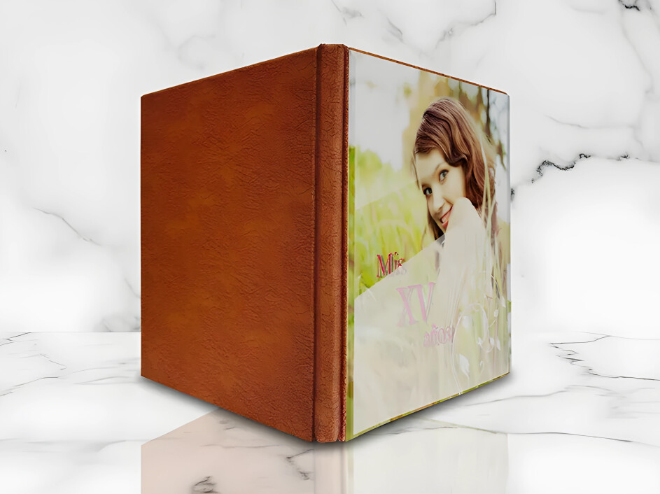 Fotobook Mi Album con empastado de acrílico y lomo en pro-piel texturizada color miel, sobre fondo de mármol blanco.