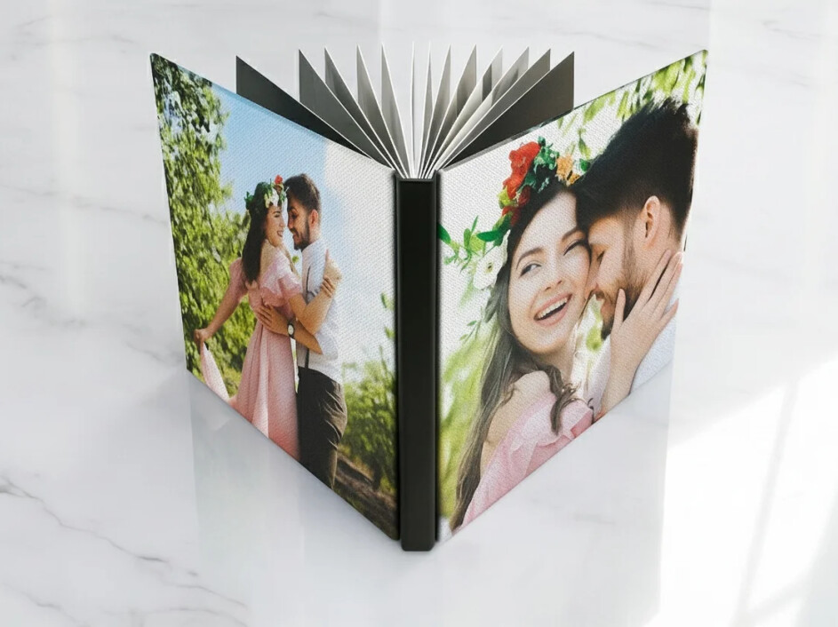 Fotobook abierto con empastado en canvas mate, mostrando continuidad de imagen entre portada y contraportada, con hojas interiores planas.