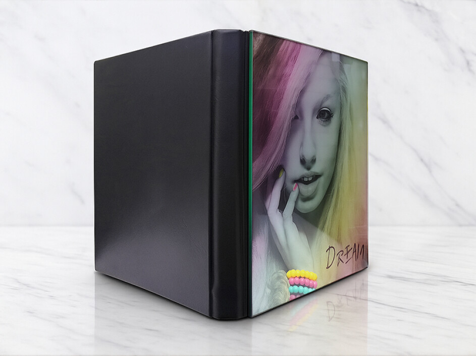 Fotobook Cristal Foto Portada Mi Album en ángulo tres cuartos; se aprecia la contraportada lisa en pro-piel y cristal frontal de alto brillo.
