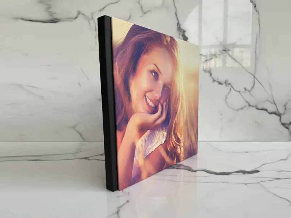 Fotobook Layflat Mi Album con empastado en canvas exhibido en mesa moderna, iluminación cálida y fondo minimalista en sala contemporánea.